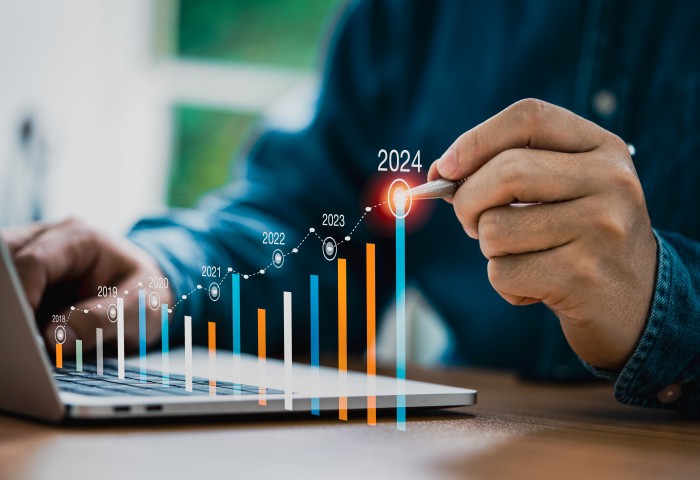 Businessman use electronic pen writing rising colorful graph from 2023 to 2024 year of business planing and stock investment growth concept.